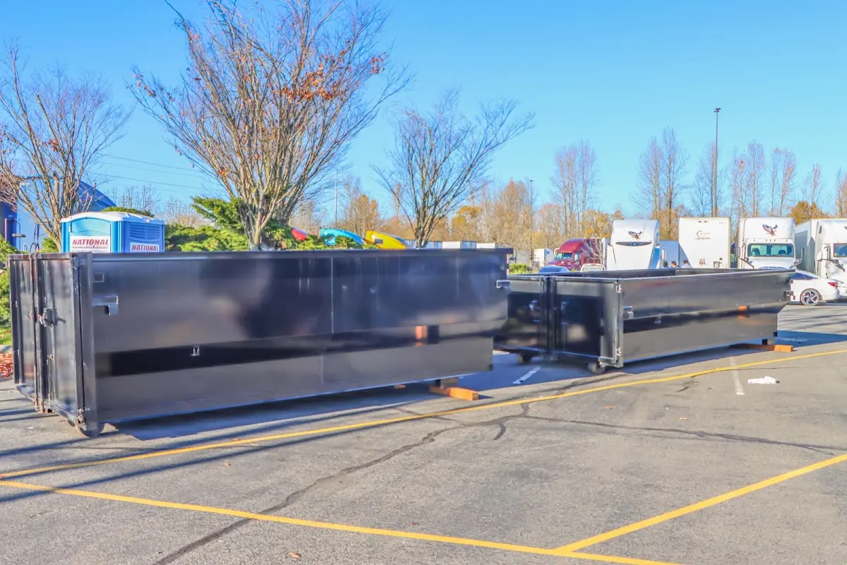 Professional dumpster rental service with roll-off container on residential driveway in Kermit